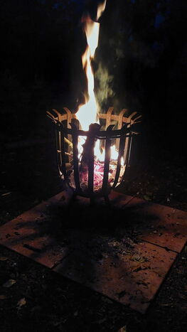 Ein Lagerfeuer in einem Feuerkorb bei Nacht