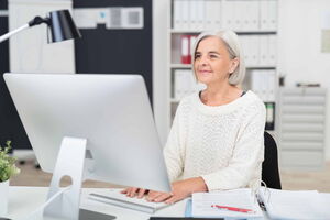 Erfolgreich im Beruf sein Eine erfahrene Frau sitzt an einem Computerbildschirm und sieht zufrieden aus. Die Arbeit macht ihr Spaß. Ich unterstütze Sie dabei, dass auch Ihnen die Arbeit wieder Spaß macht.