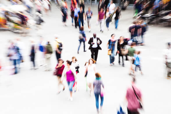 Ein Mann steht inmitten eines vollen Platzes. Alles um ihn herum bewegt sich schnell. Wie gelähmt steht er in der Mitte und ist unfähig, sich zu bewegen.